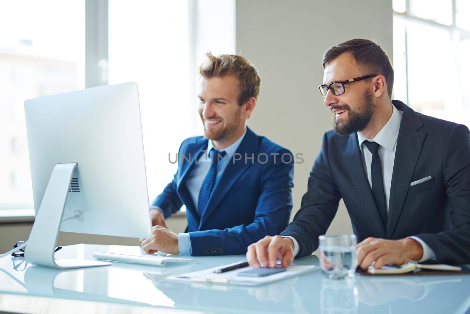 Modern businessmen consulting in front of computer at meeting
