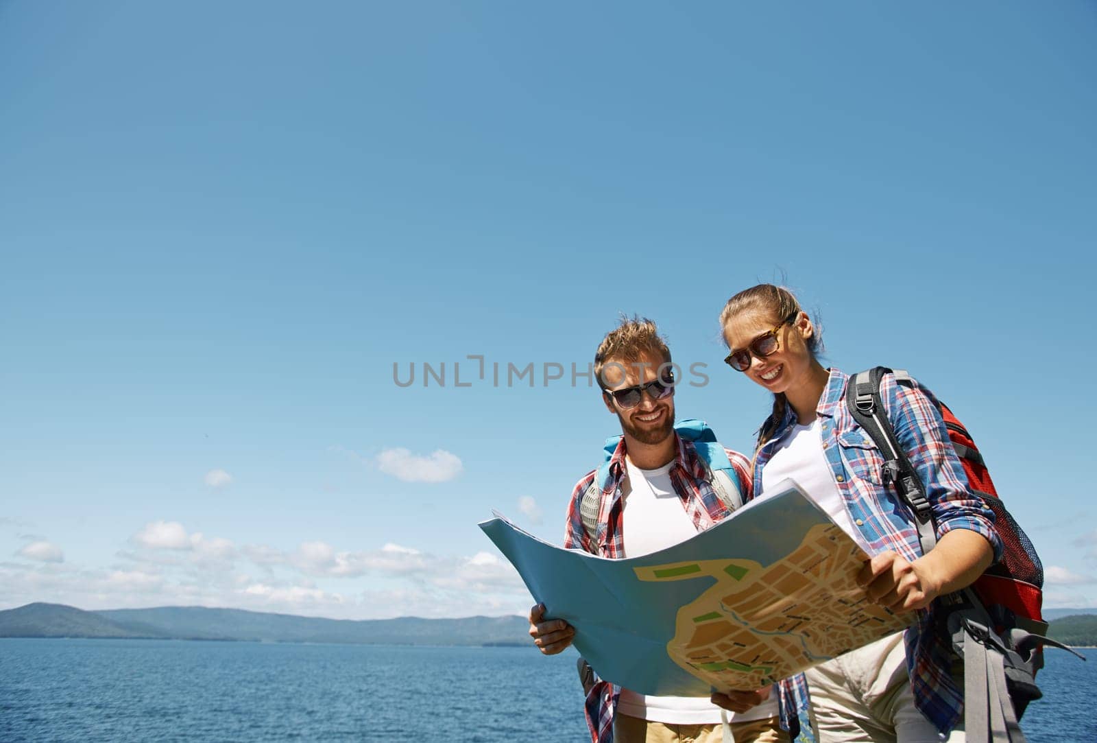 Cheerful hikers looking at guide during their trip