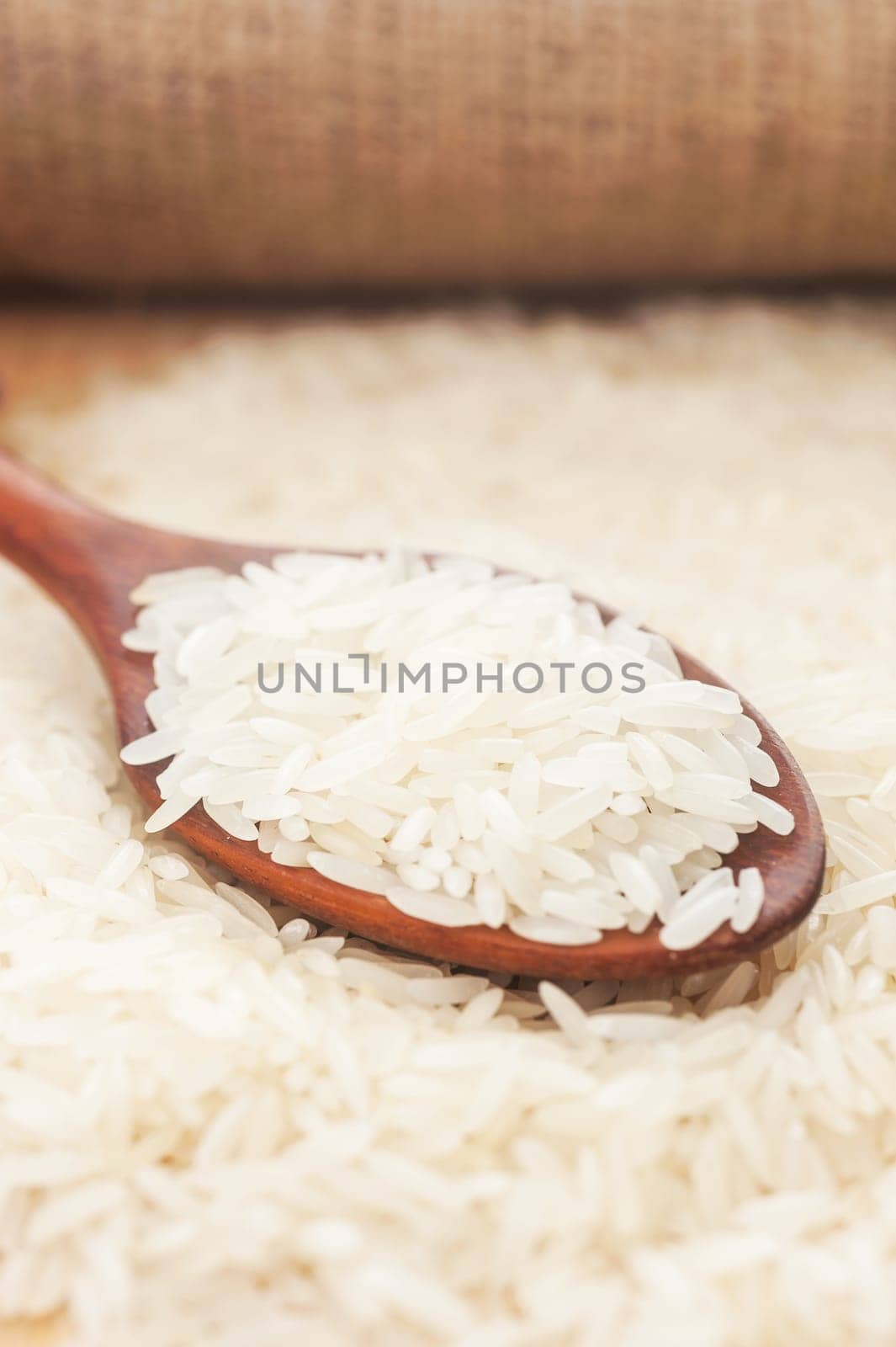 Rice, White rice in wooden spoon with hemp background, Selective focus