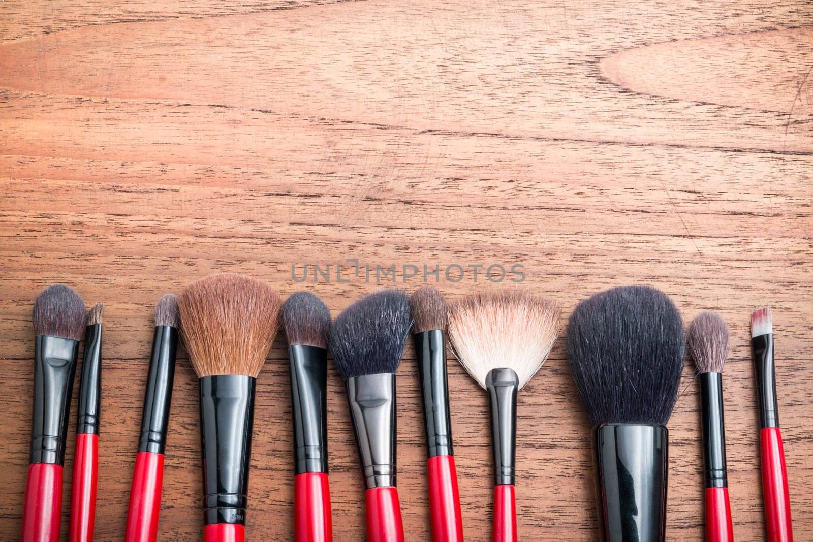 cosmetics and makeup brush, on wood table background
