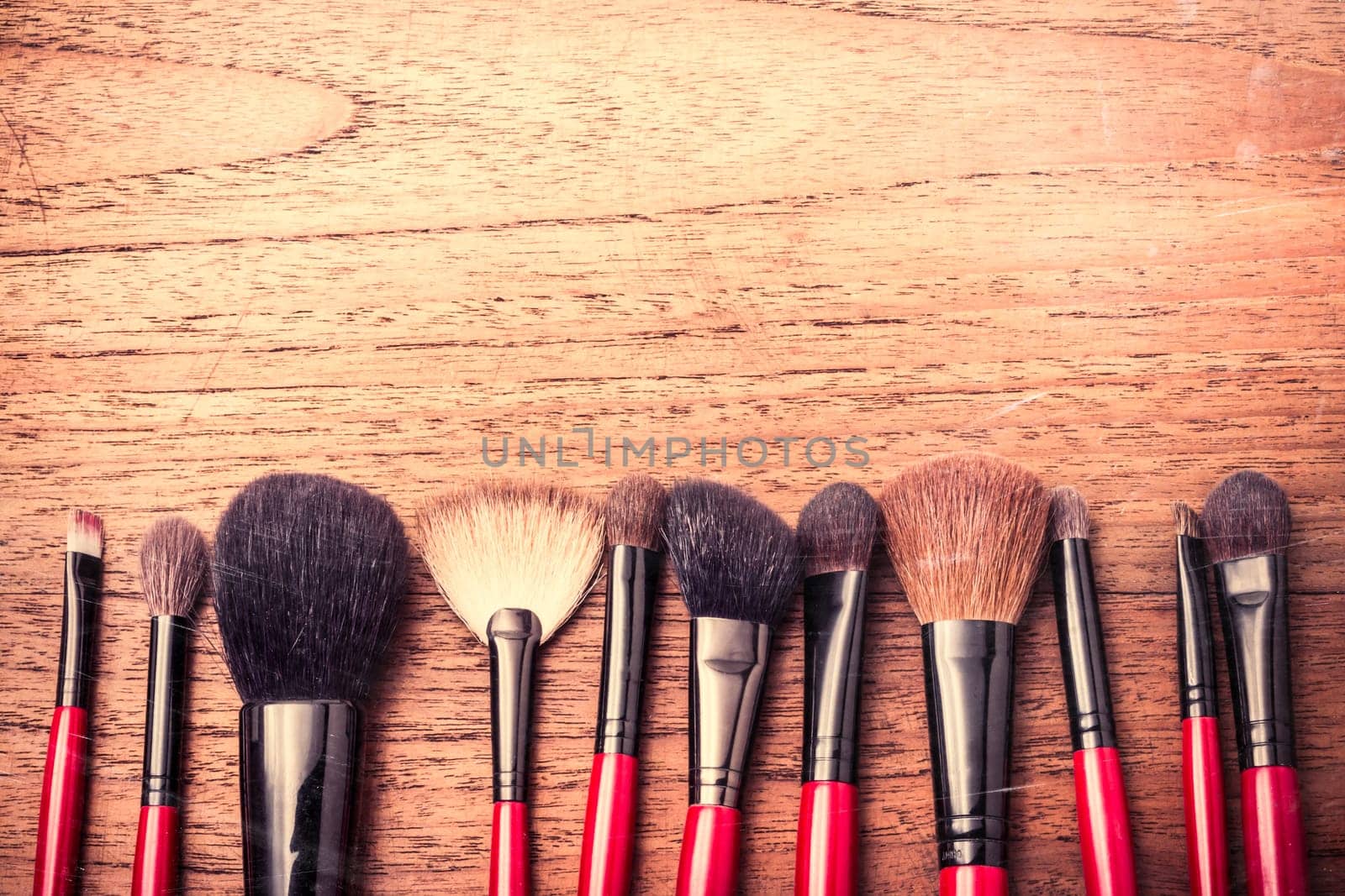 cosmetics and makeup brush, on wood table background