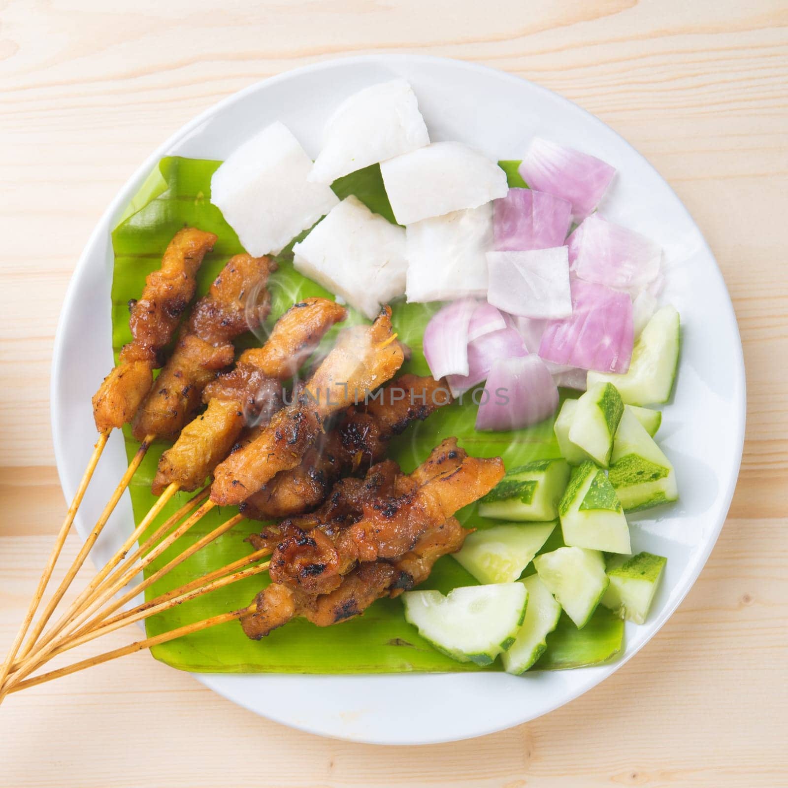 Skewered and grilled meat , chicken sate or satay, served with peanut sauce. Fresh cooked with steamed and smoke. Delicious hot and spicy Asian dish.
