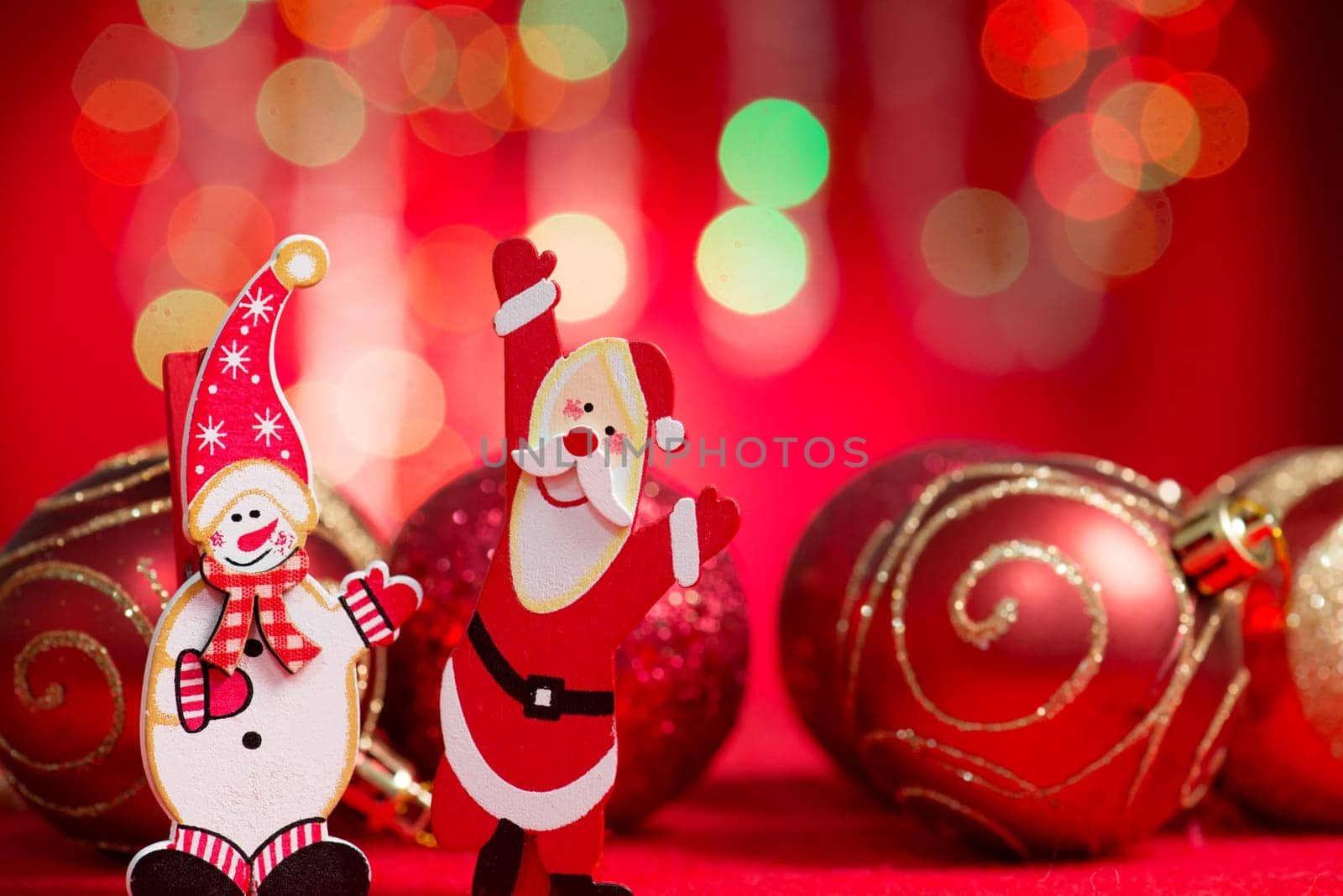 Christmas ornaments santa claus and sow man with blurry glitter shiny lights at background.