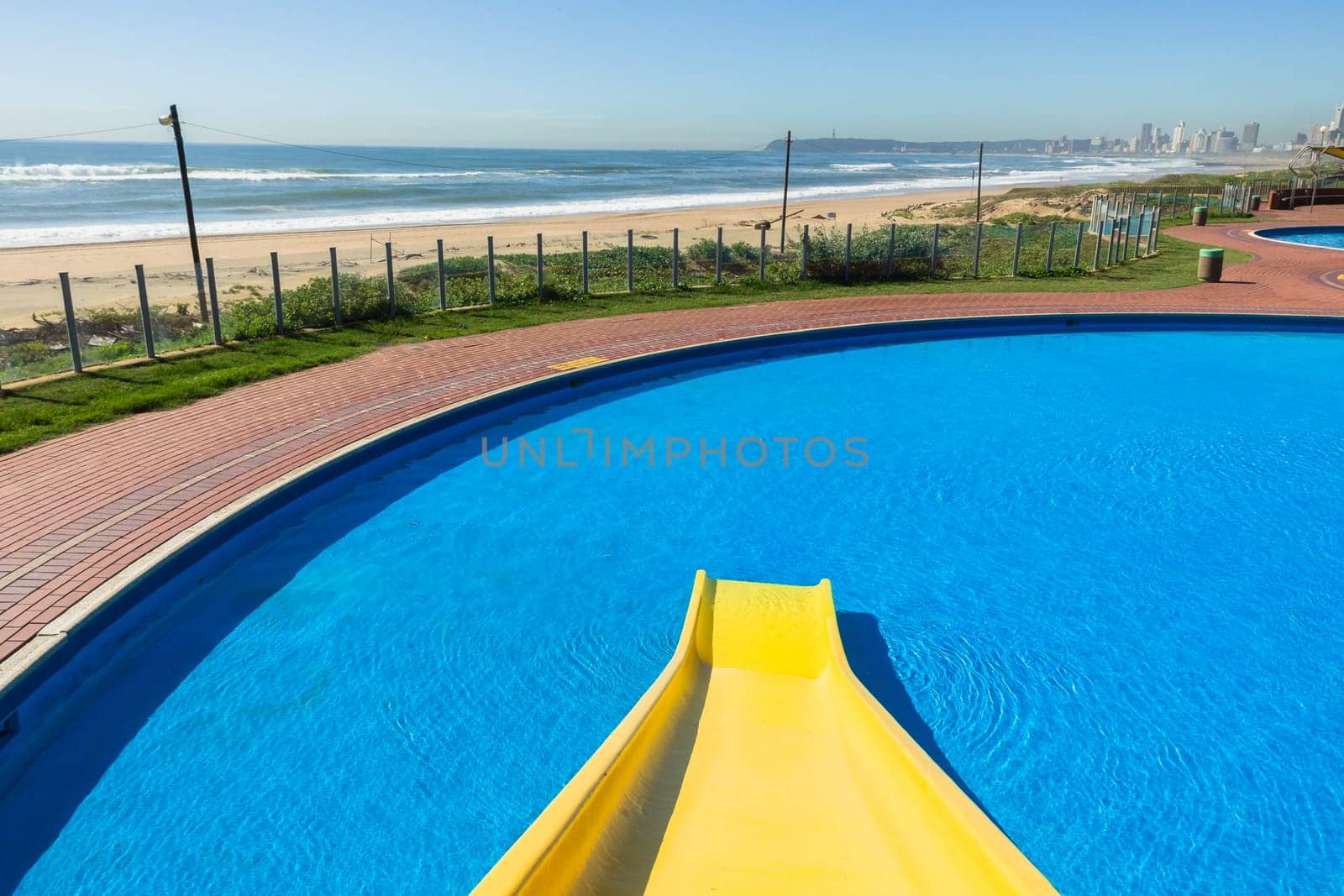 Swimming pool blue water yellow slide outdoors