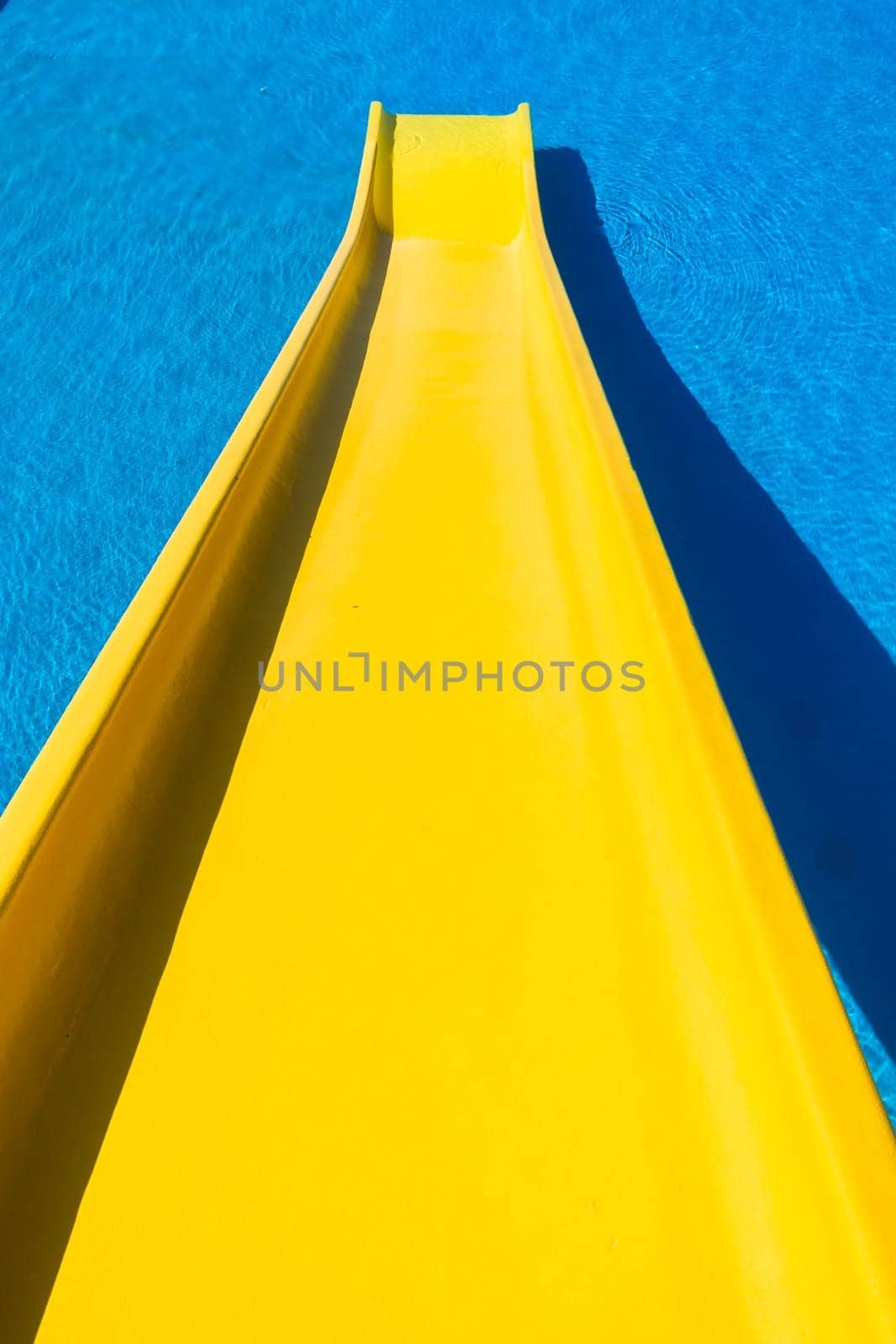 Swimming pool blue water yellow slide outdoors