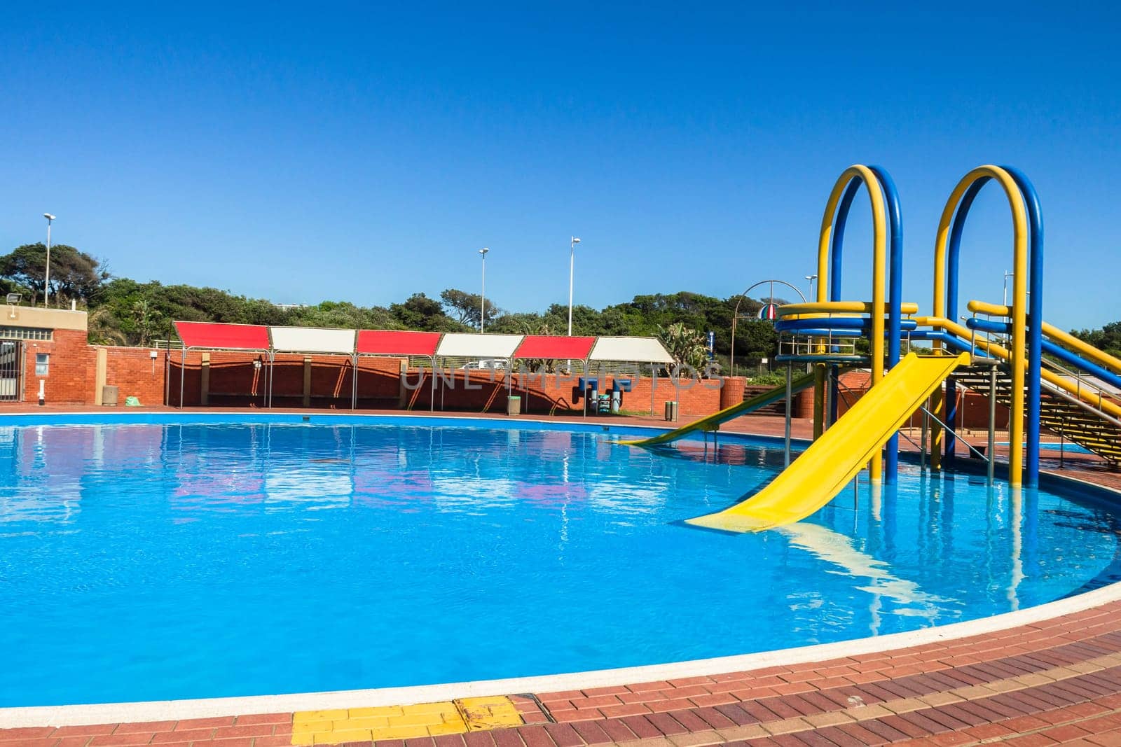 Swimming pool blue water yellow slide outdoors