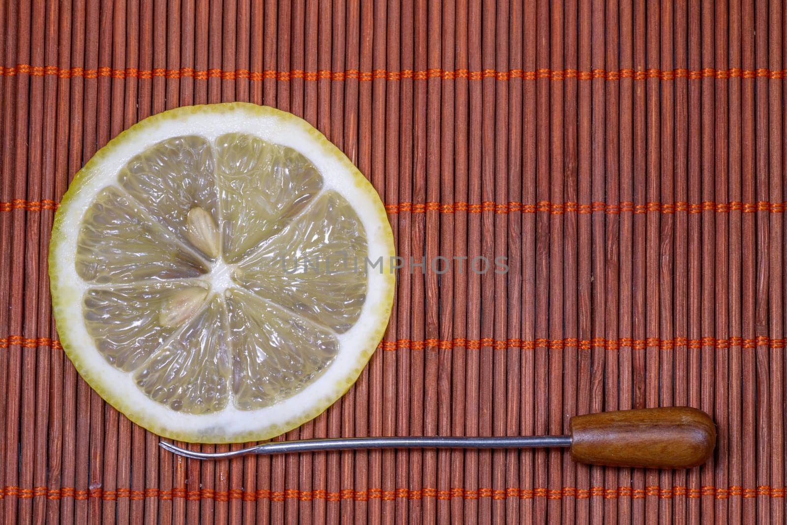 Sliced fresh lemon with forks on a nice wicker carpet as background