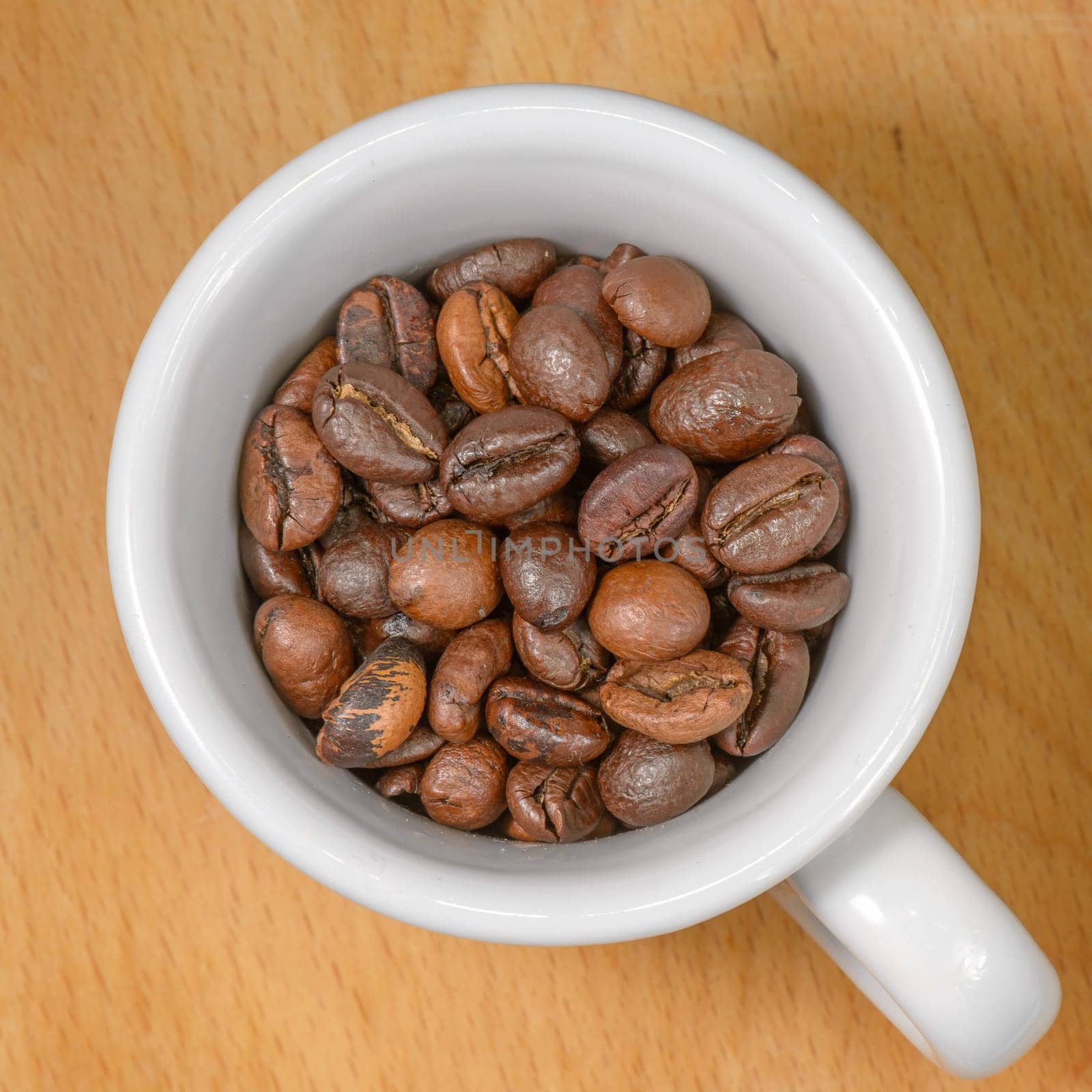 Nice cup of coffe with toasted coffee seeds inside on wood background