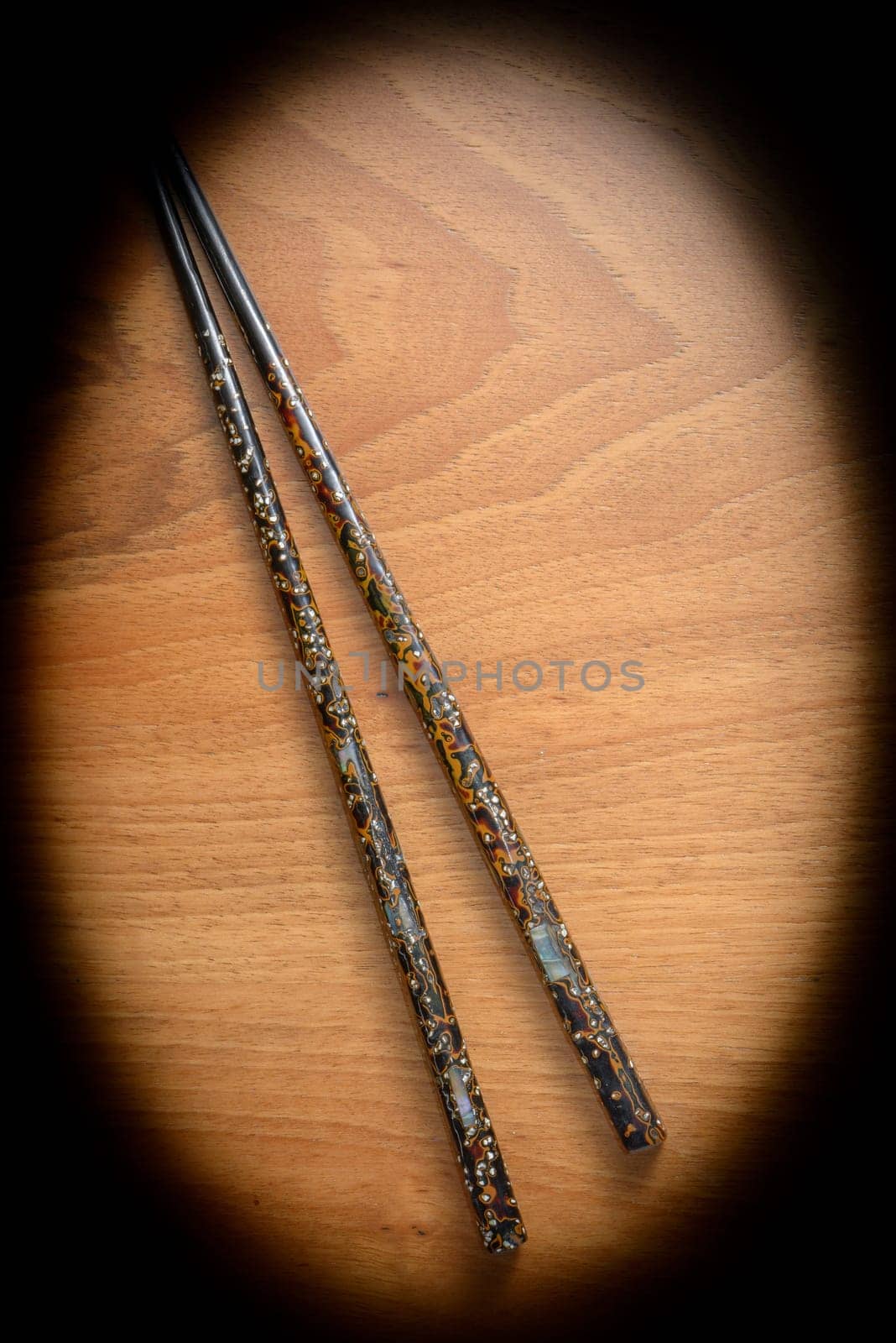 Japanese chopsticks with pearl inlays on wooden background