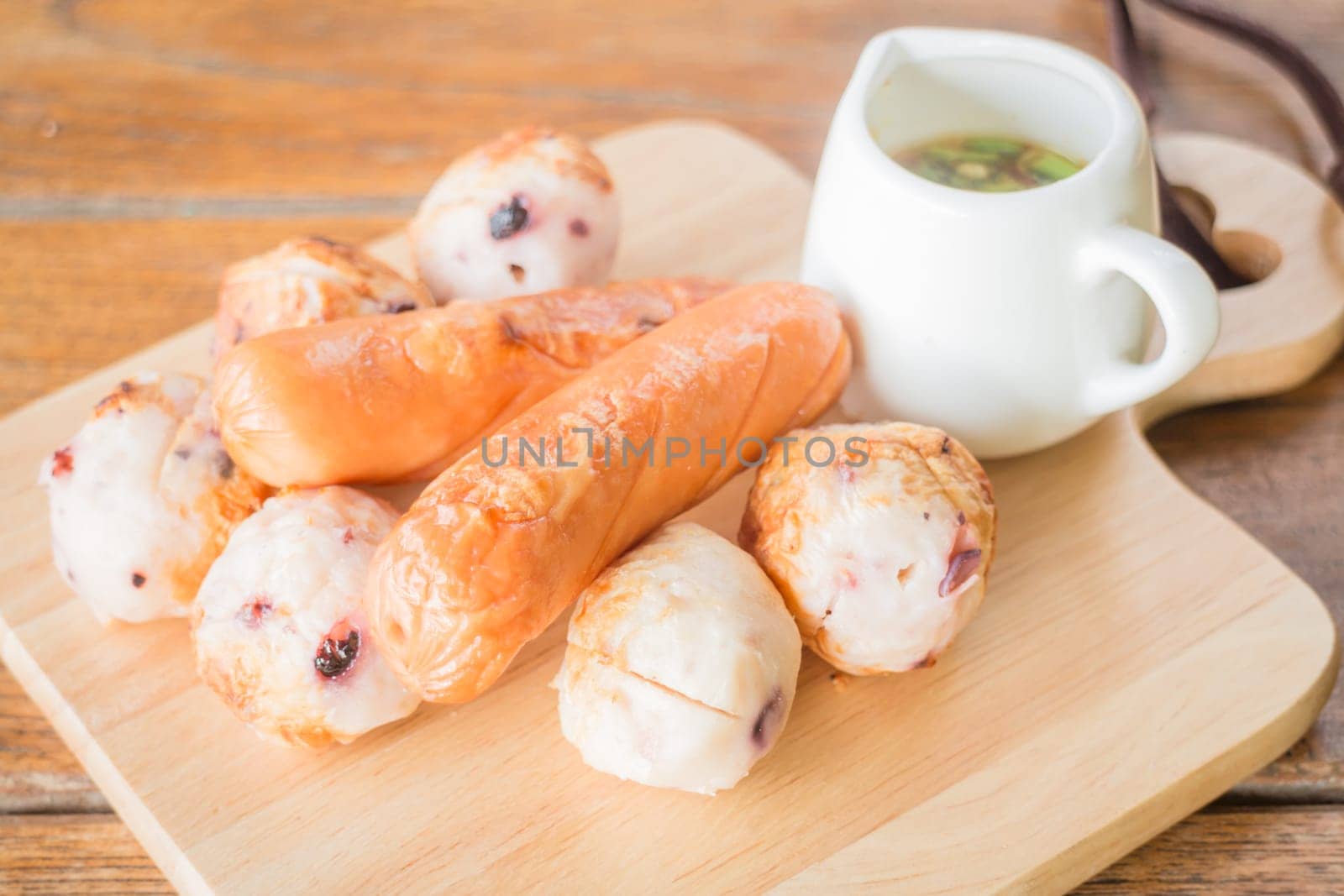 Squid ball and hotdog grilled on wooden plate, stock photo