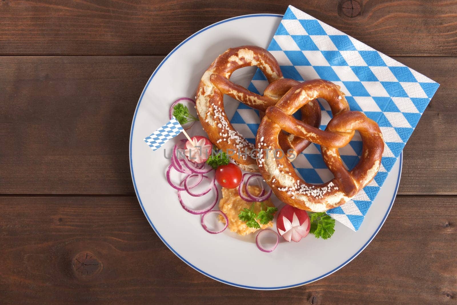 Bavarian vegetarian breakfast with two pretzels and obazda with plates on wooden boards