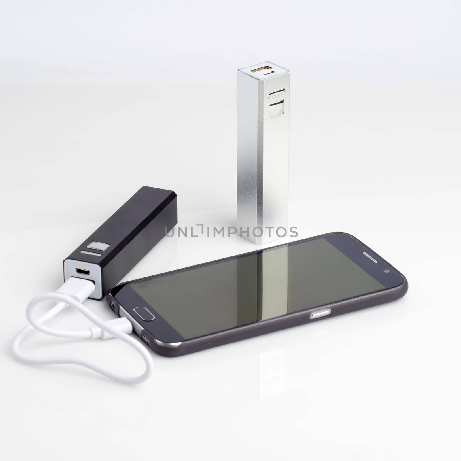 Charging a smartphone from powerbank on white table