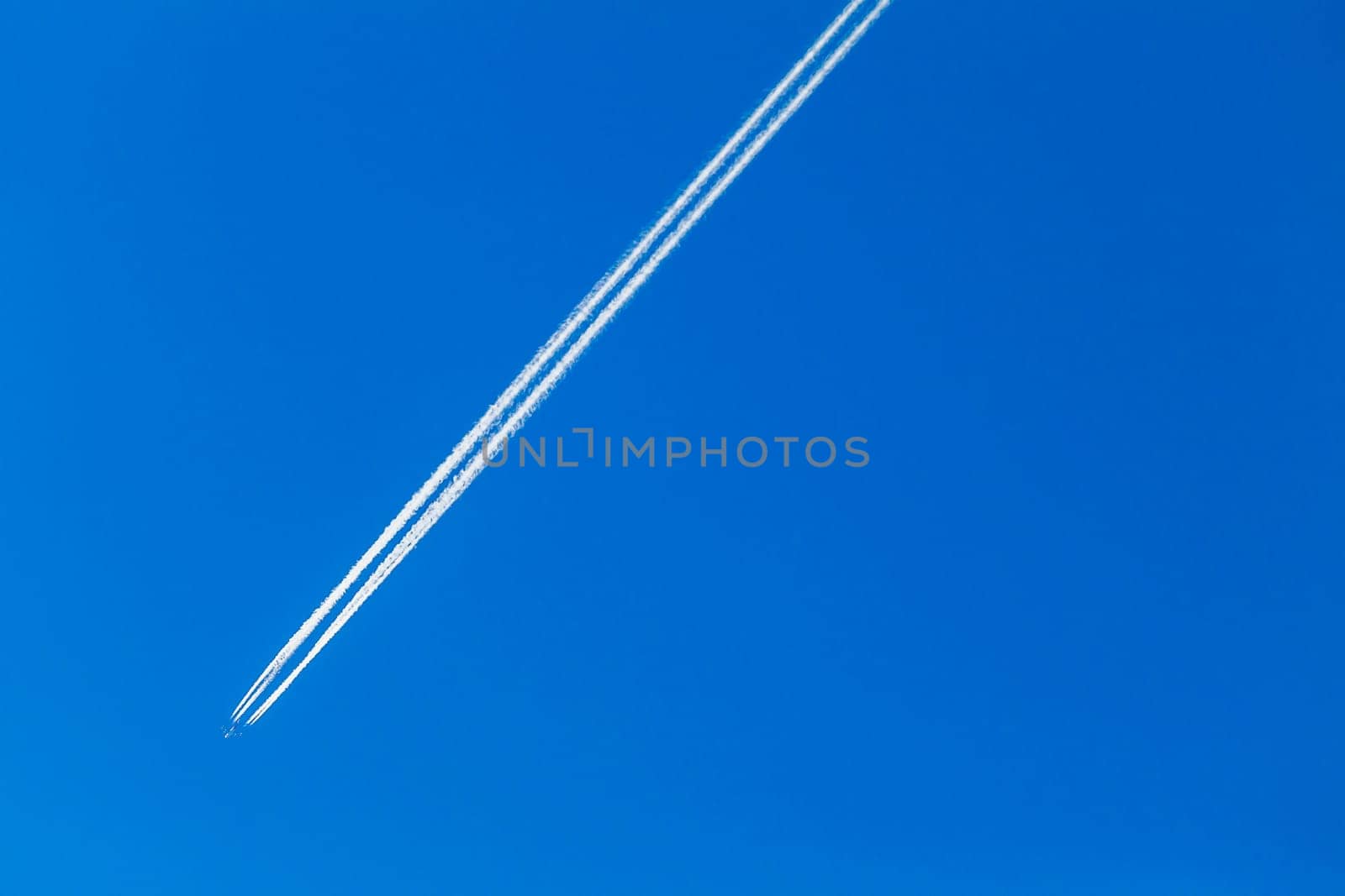 Jet Plane flying vapor white trail afternoon blue sky