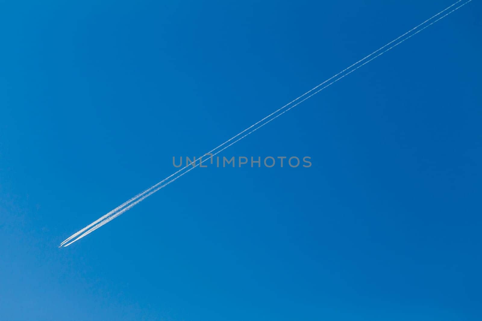 Jet Plane flying vapor white trail afternoon blue sky