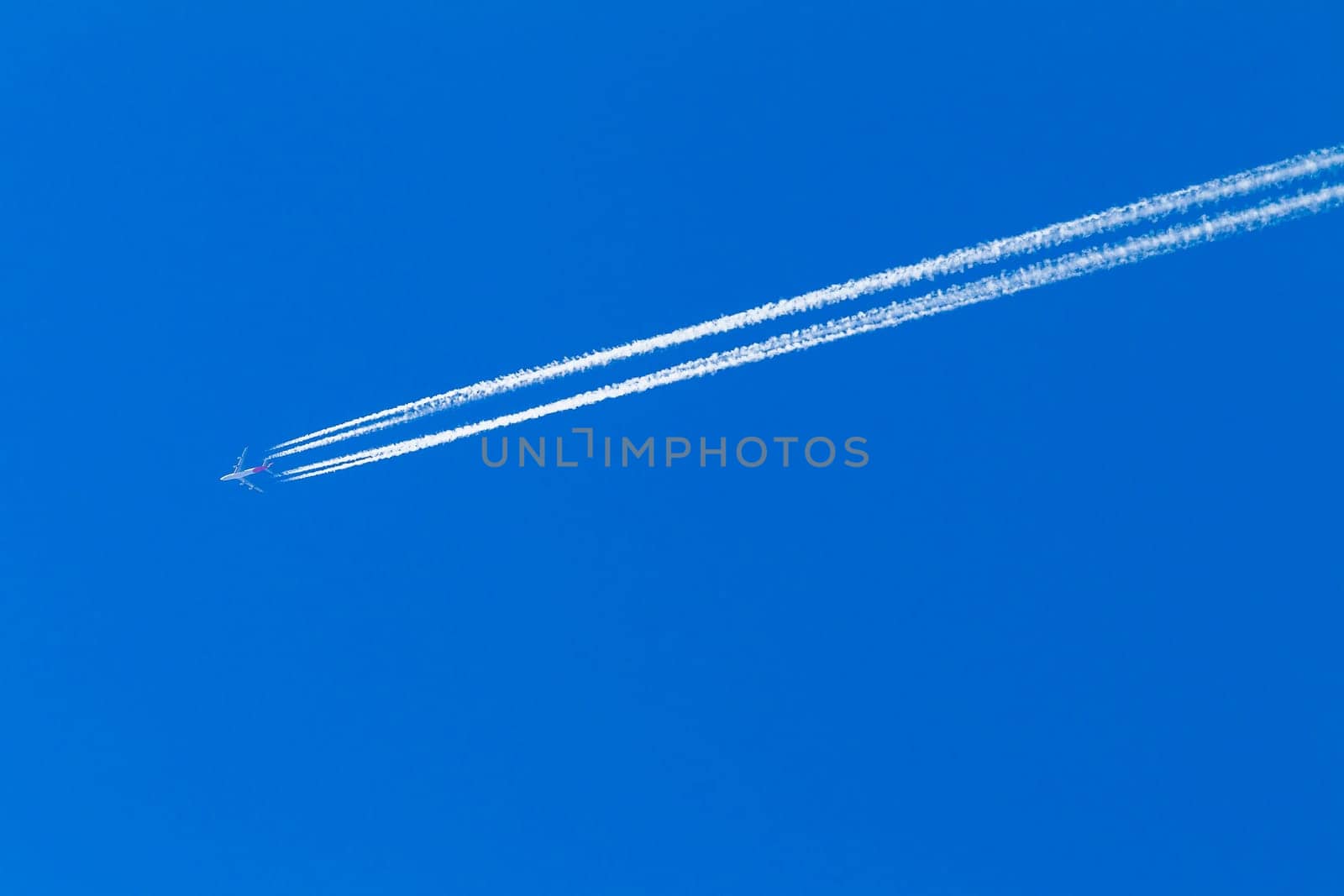 Jet Plane flying vapor white trail afternoon blue sky