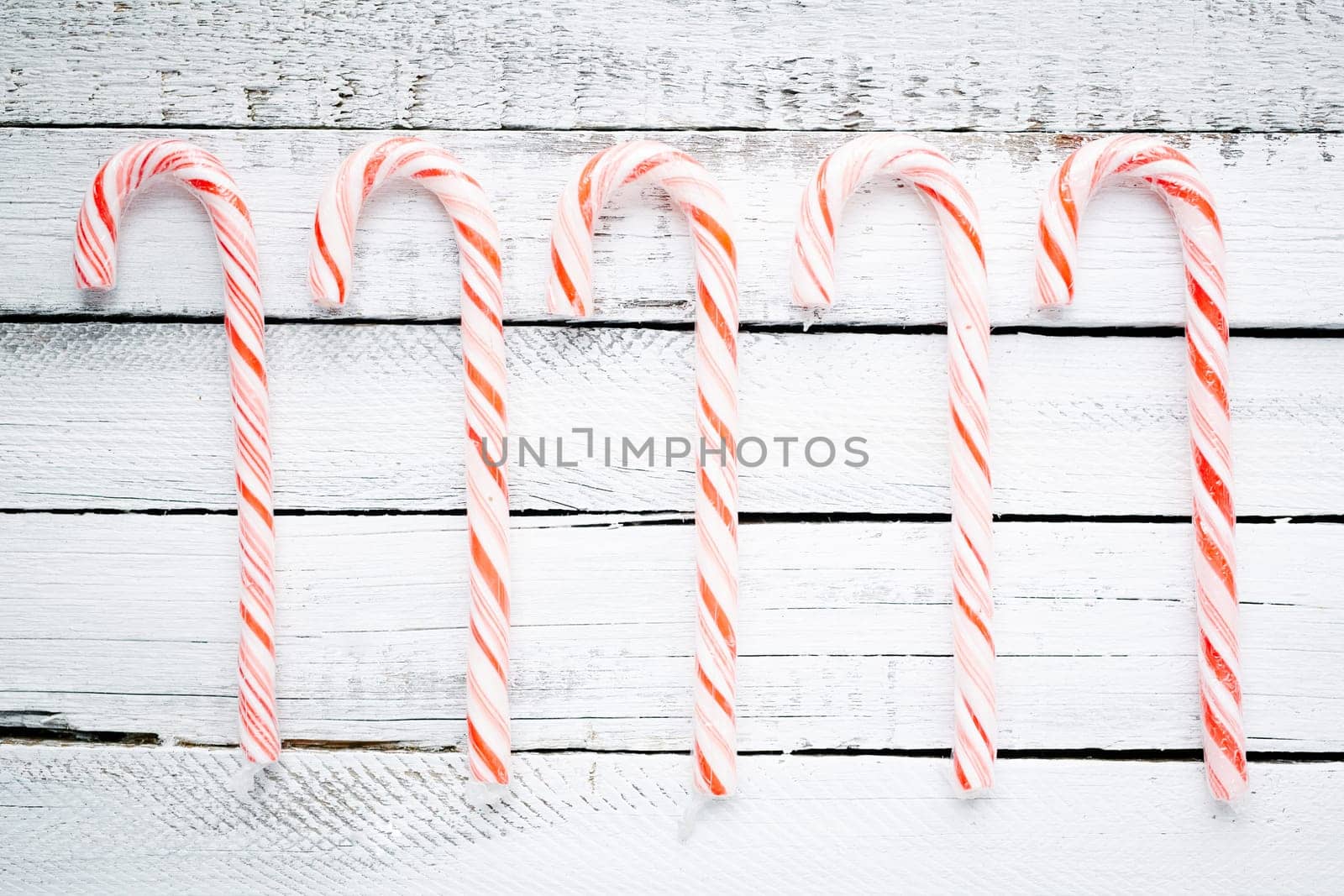 Several sweet canes over wooden background