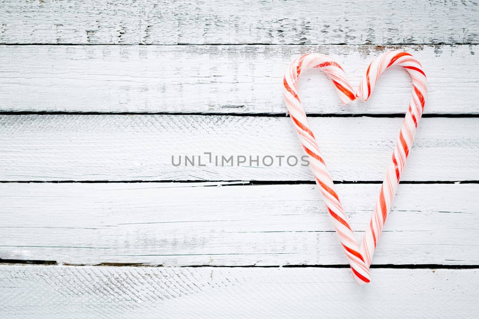 Candy cane heart on wooden background