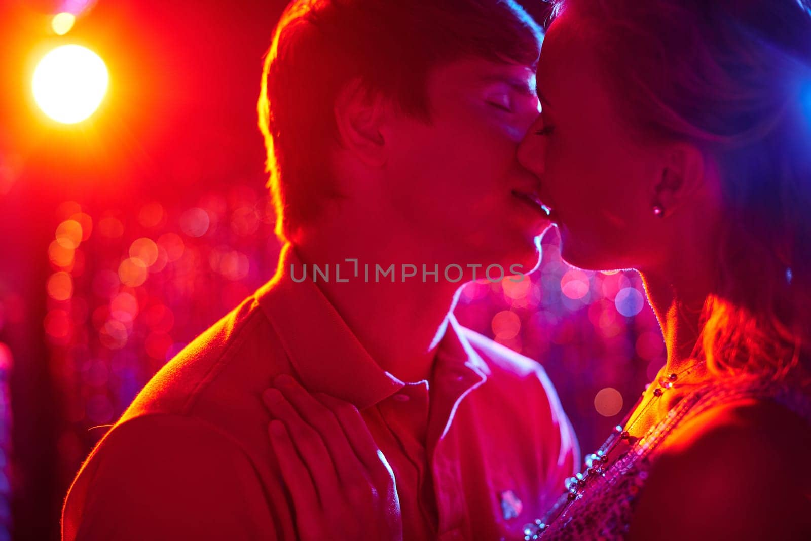 Romantic couple kissing in night club
