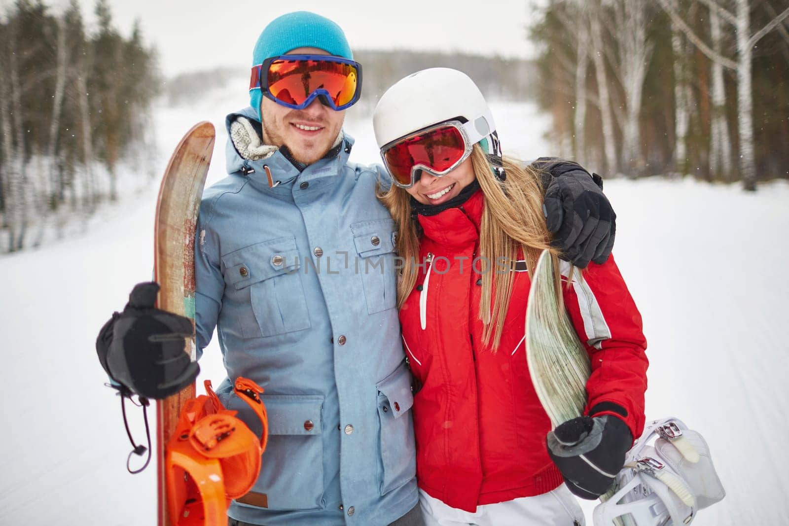 Couple of young snowboarders spending vacation on winter resort