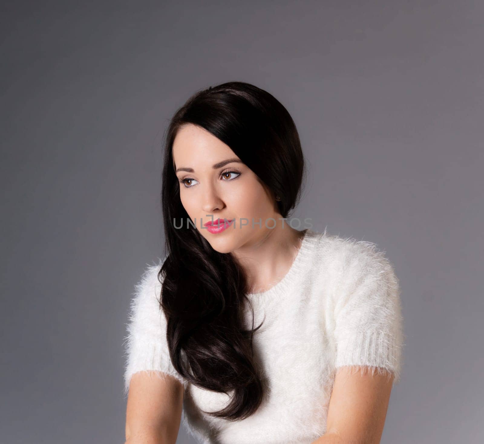 portrait of pretty brunette woman in white sweater.
