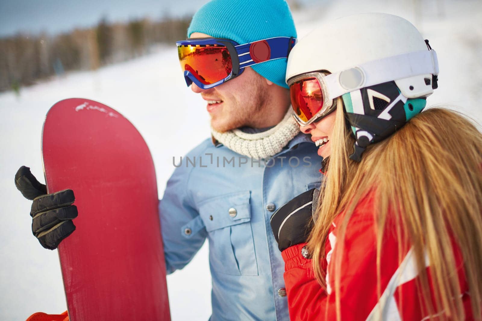Amorous snowboarders in winter activewear spending vacation at sportive resort