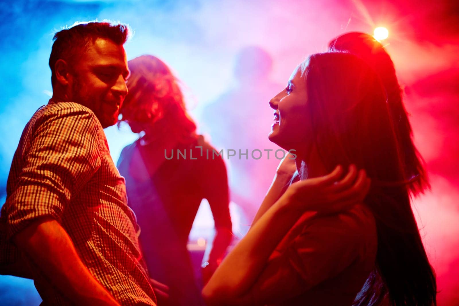 Happy young couple dancing at party in disco club