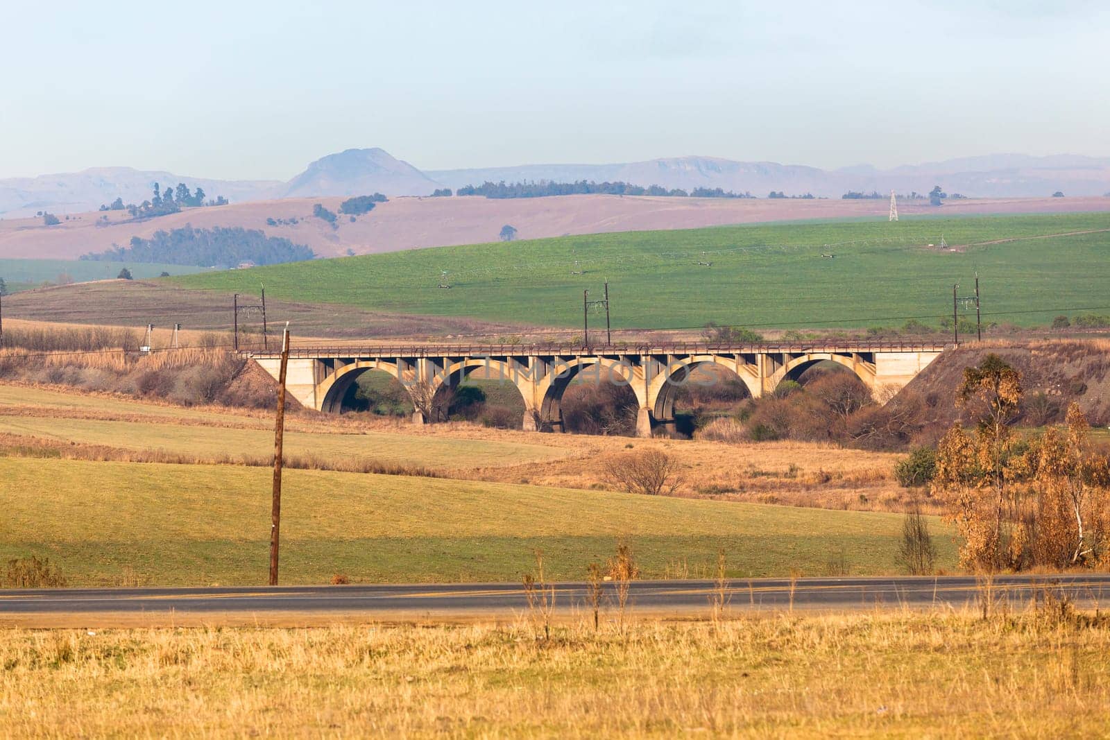 Rural farming fields alongside railway train bridge road scenic landscape