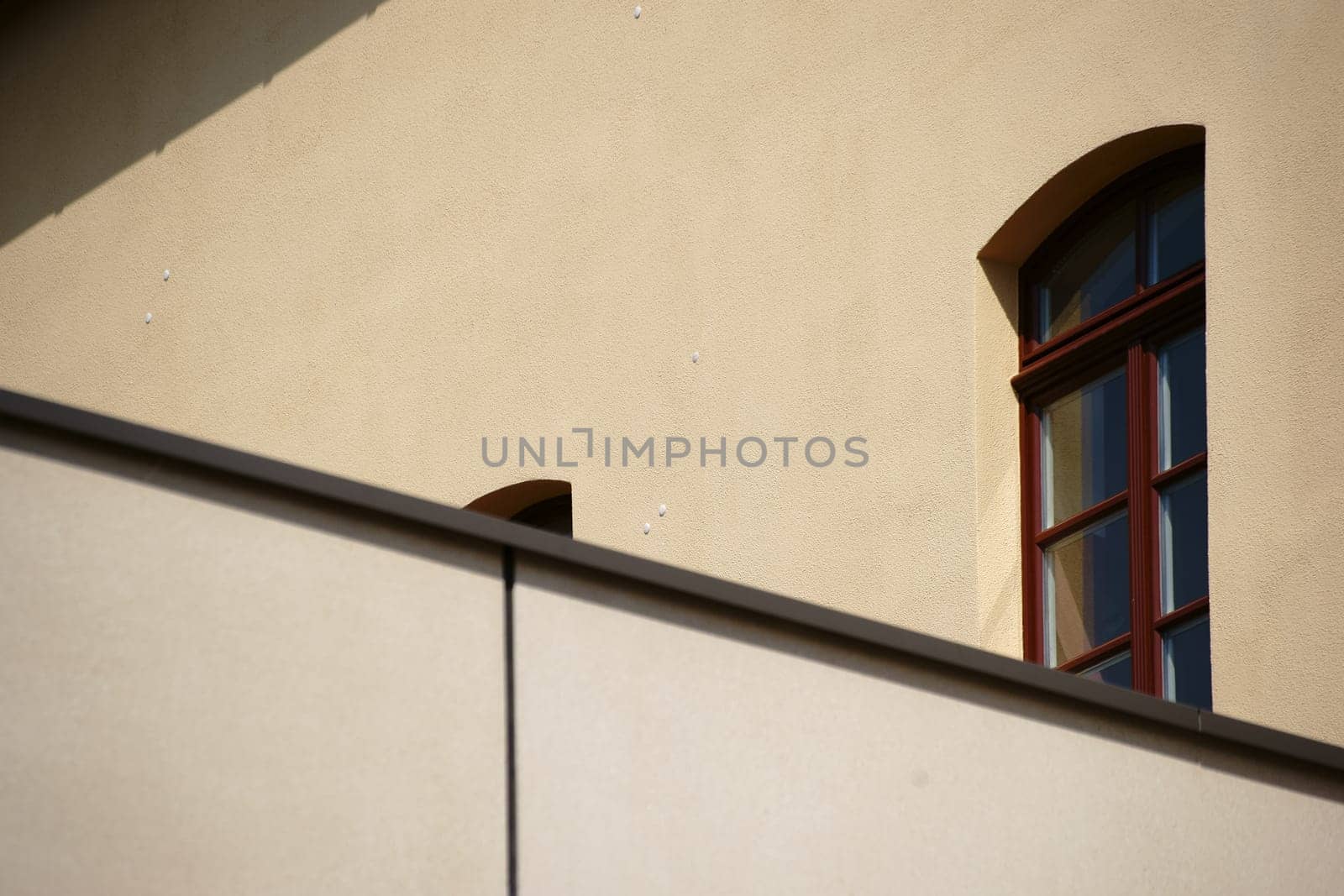 A roof edge with a facade behind it of a building with windows.