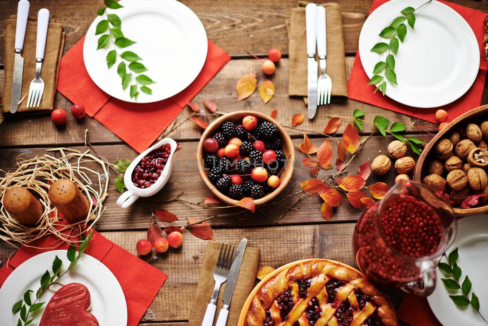 Fresh rennets, walnuts, pastry, jam, fruit drink, berries and tableware on served table