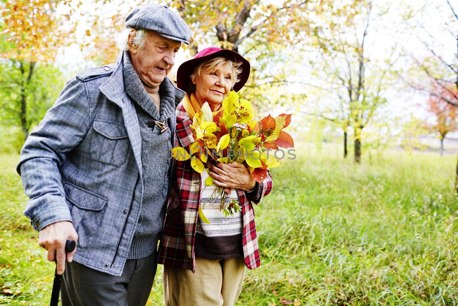 Retired couple walking in park on autumn weekend