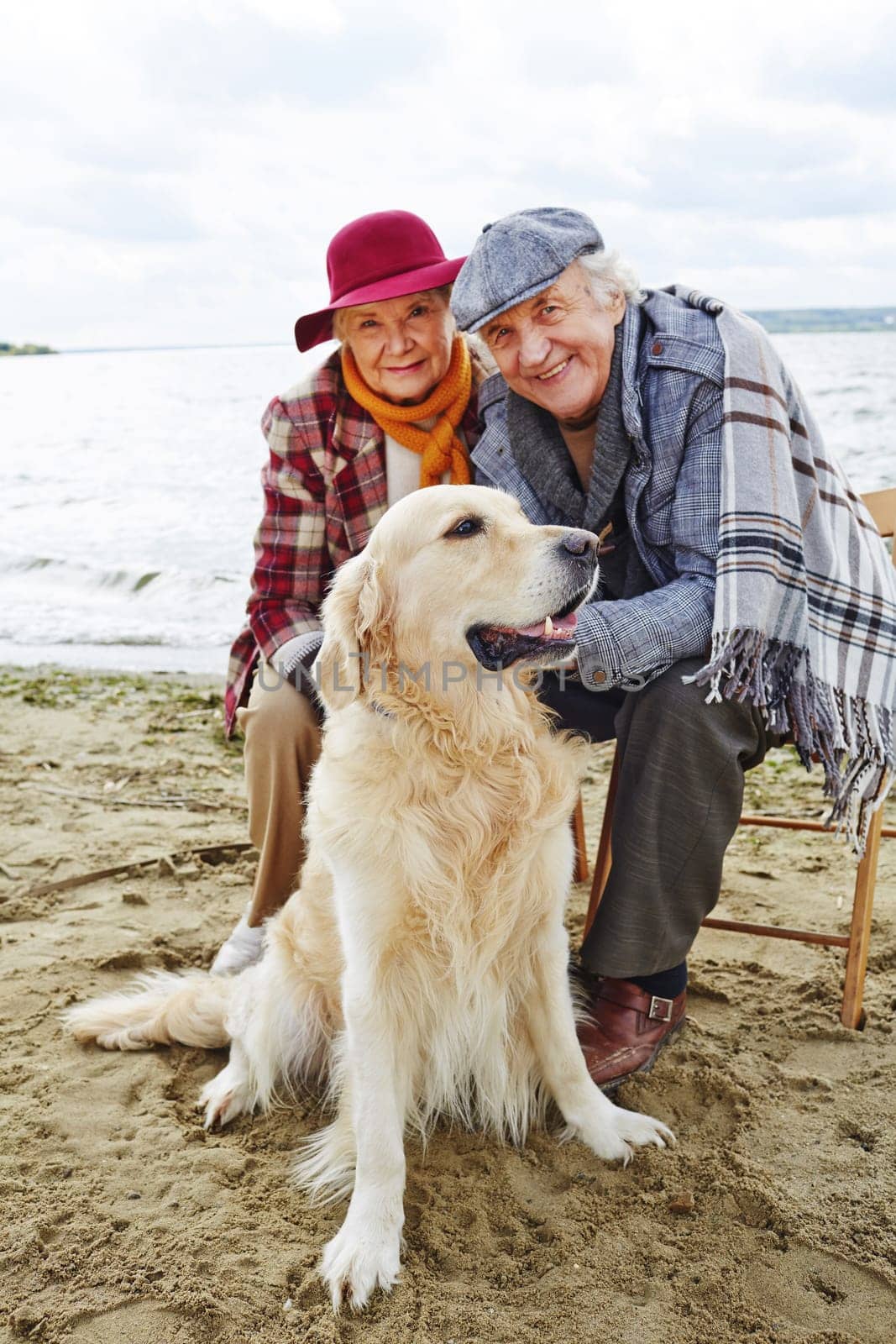 Retired couple with labrador spending time by seaside