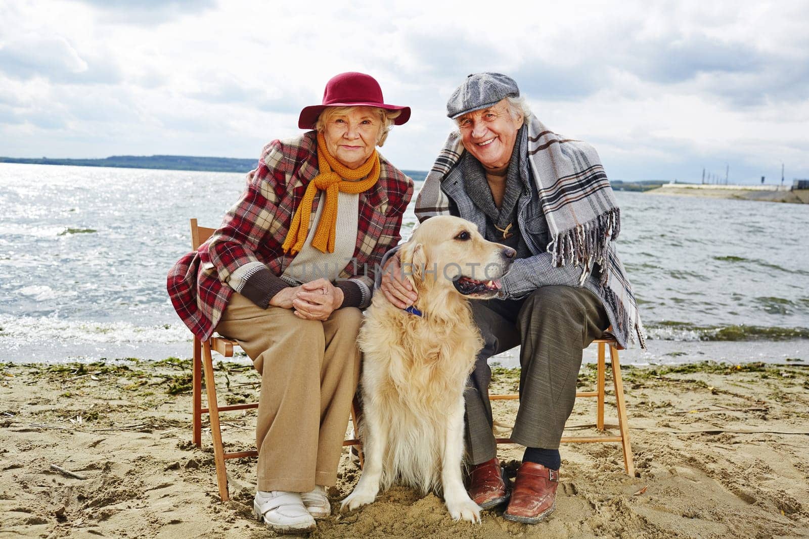Two pensioners and their pet spending weekend together by seaside