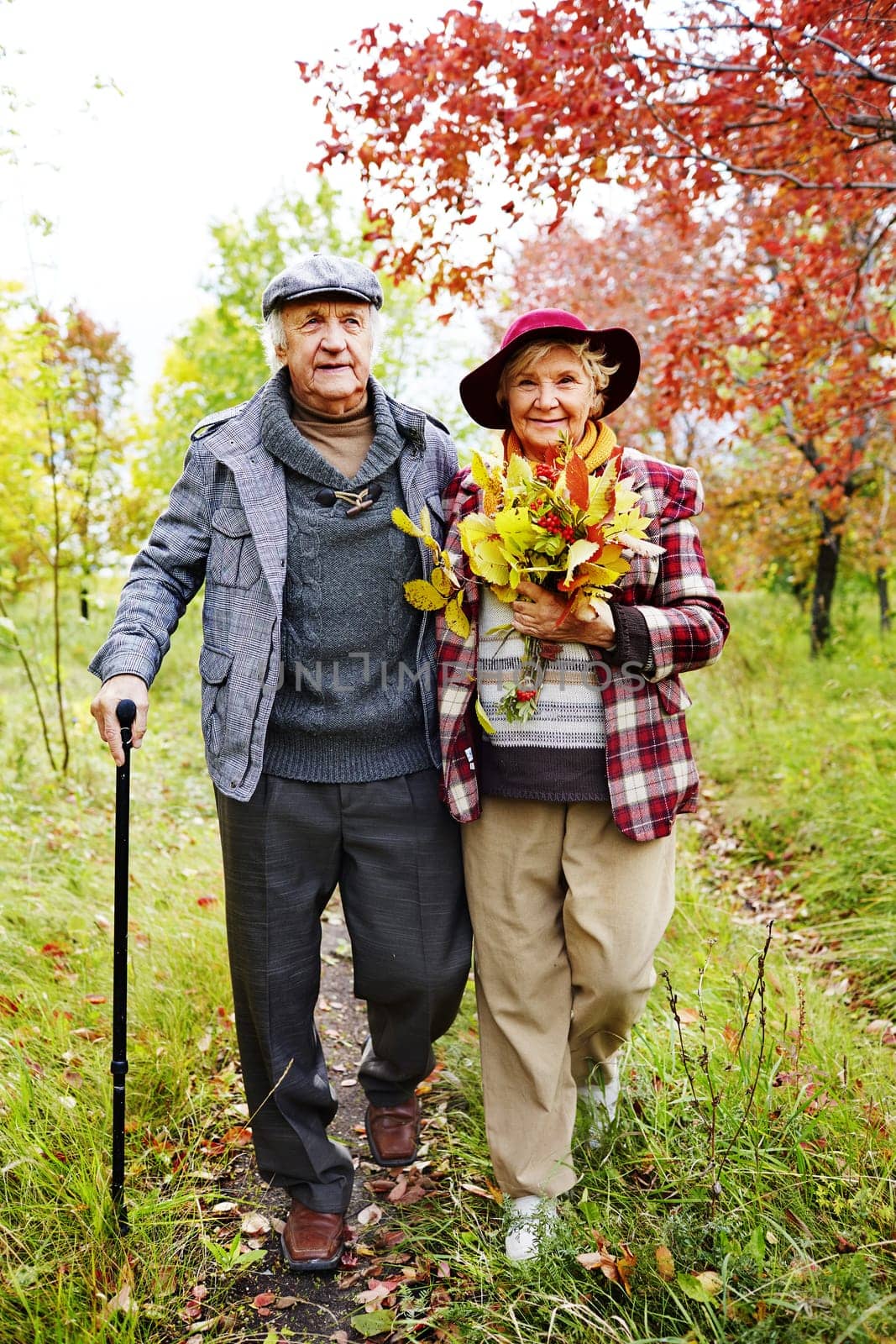 Retired couple warm casualwear walking in park at leisure