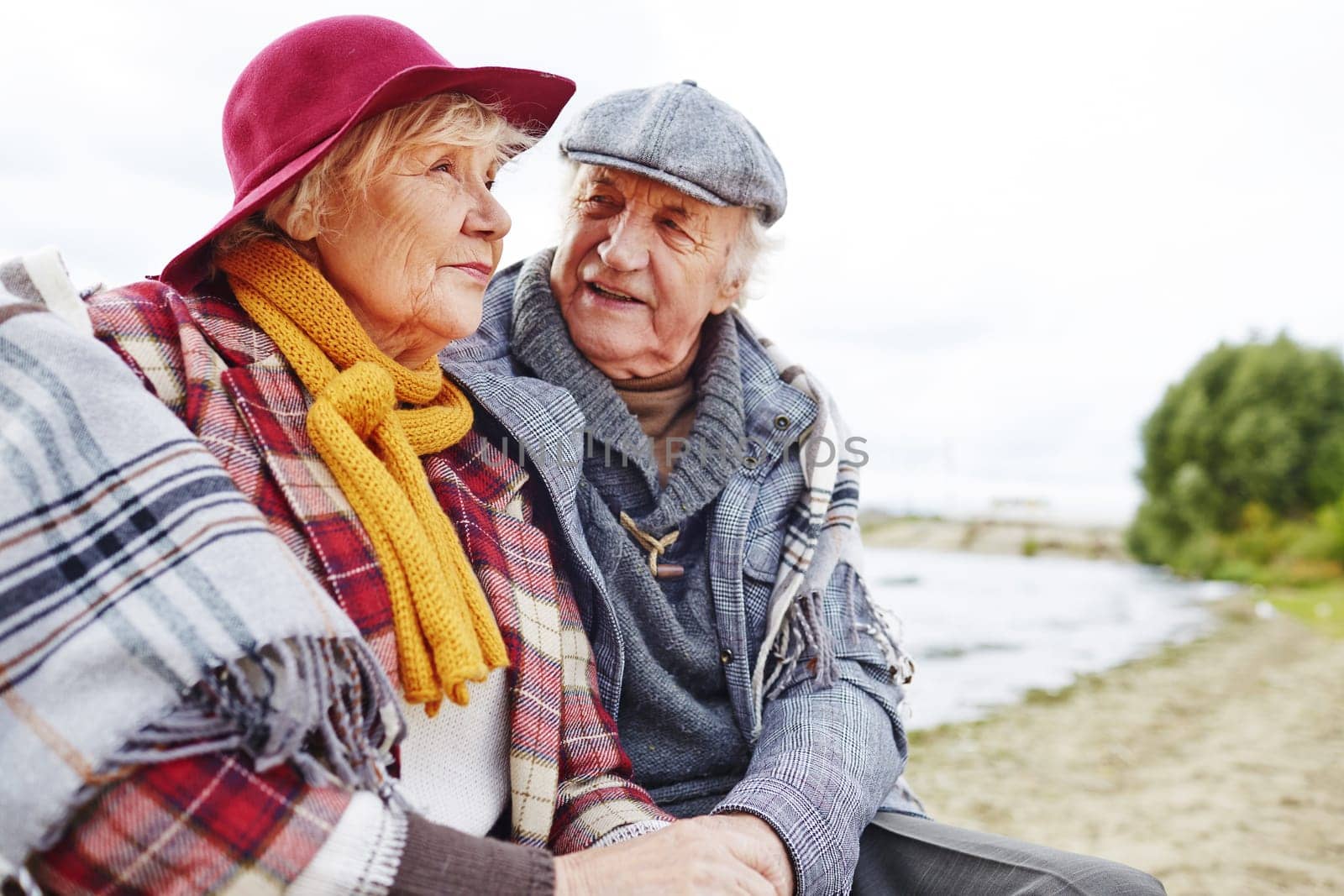 Retired couple in warm clothes having outdoor rest