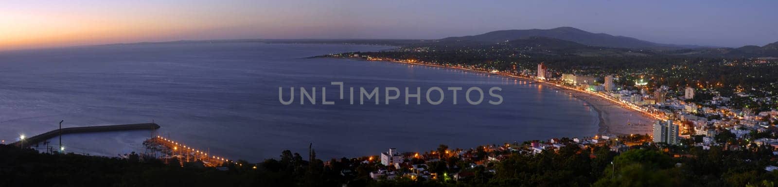 Summer beach panoramic cityscape with clear sunset and seashore aerial view. Piriapolis, Uruguay.