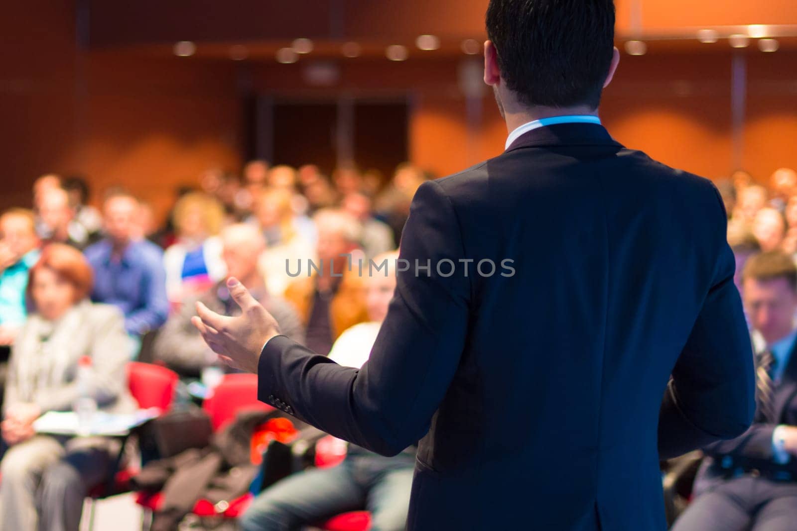 Speaker at Business Conference with Public Presentations. Audience at the conference hall. Entrepreneurship club. Rear view. Horisontal composition. Background blur.