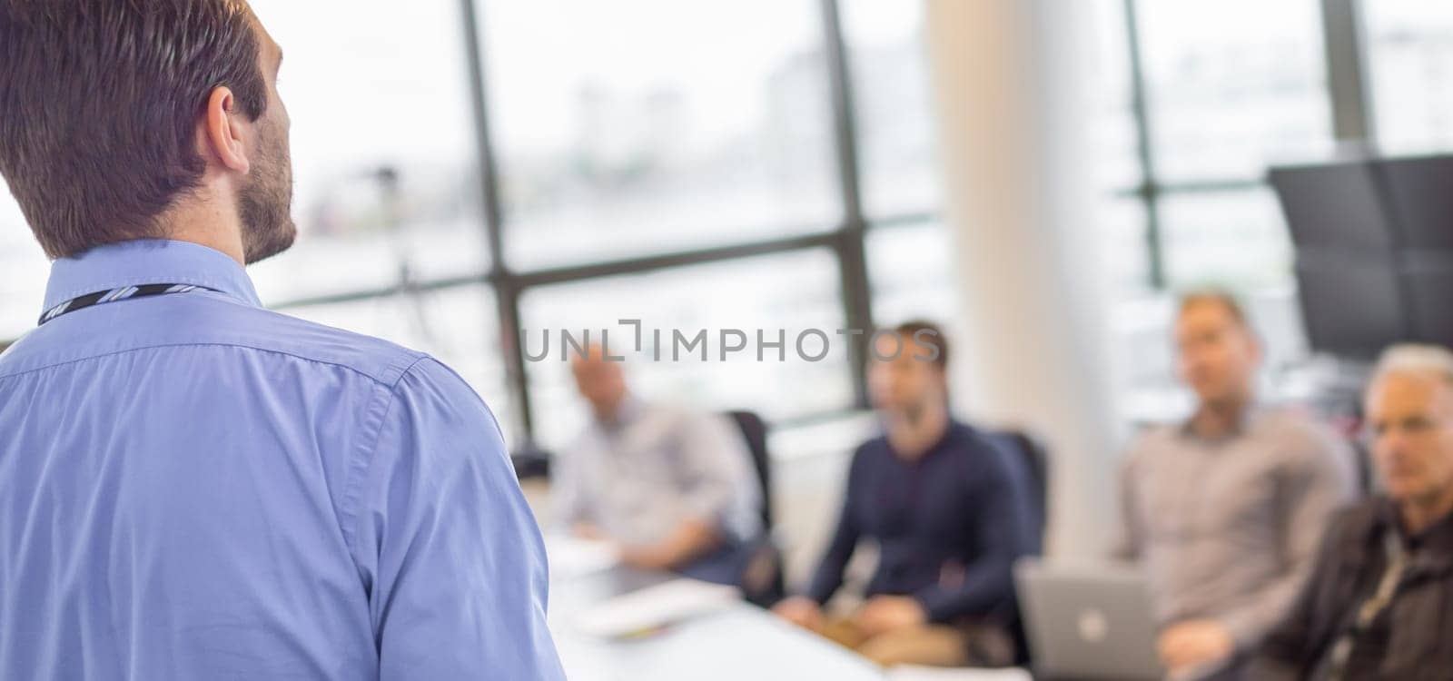 Business man making a presentation at office. Business executive delivering a presentation to his colleagues during meeting or in-house business training, explaining business plans to his employees.