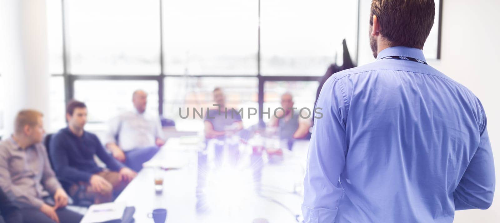 Business man making a presentation at office. Business executive delivering a presentation to his colleagues during meeting or in-house business training, explaining business plans to his employees.