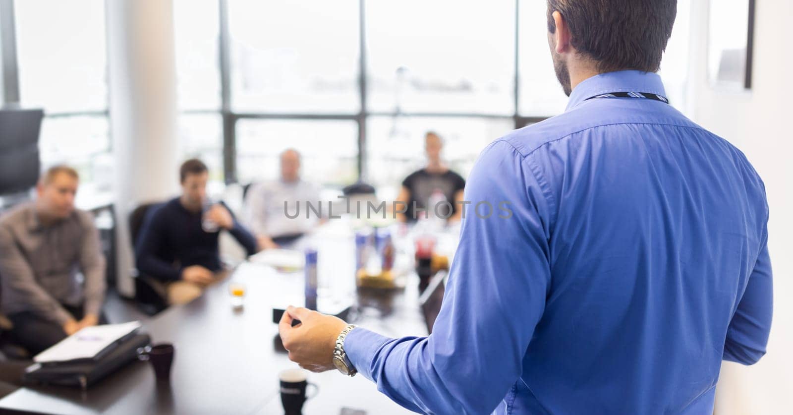 Business man making a presentation at office. Business executive delivering a presentation to his colleagues during meeting or in-house business training, explaining business plans to his employees.