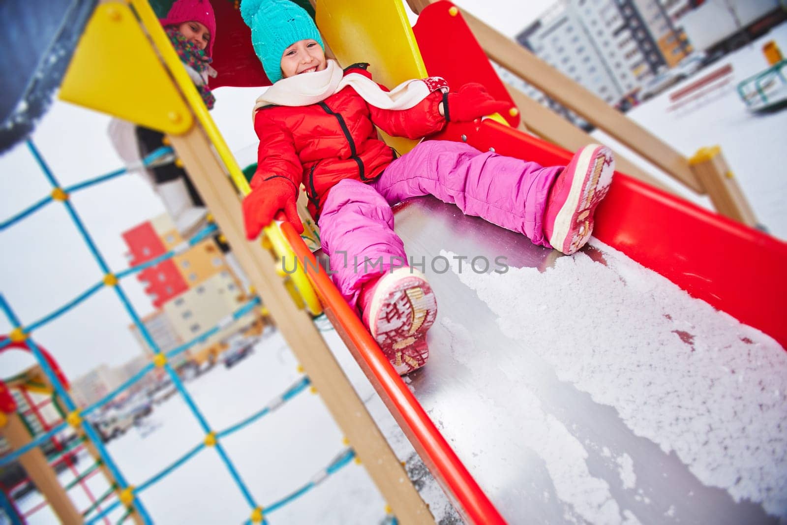 Two girls in winterwear spending leisure outdoors