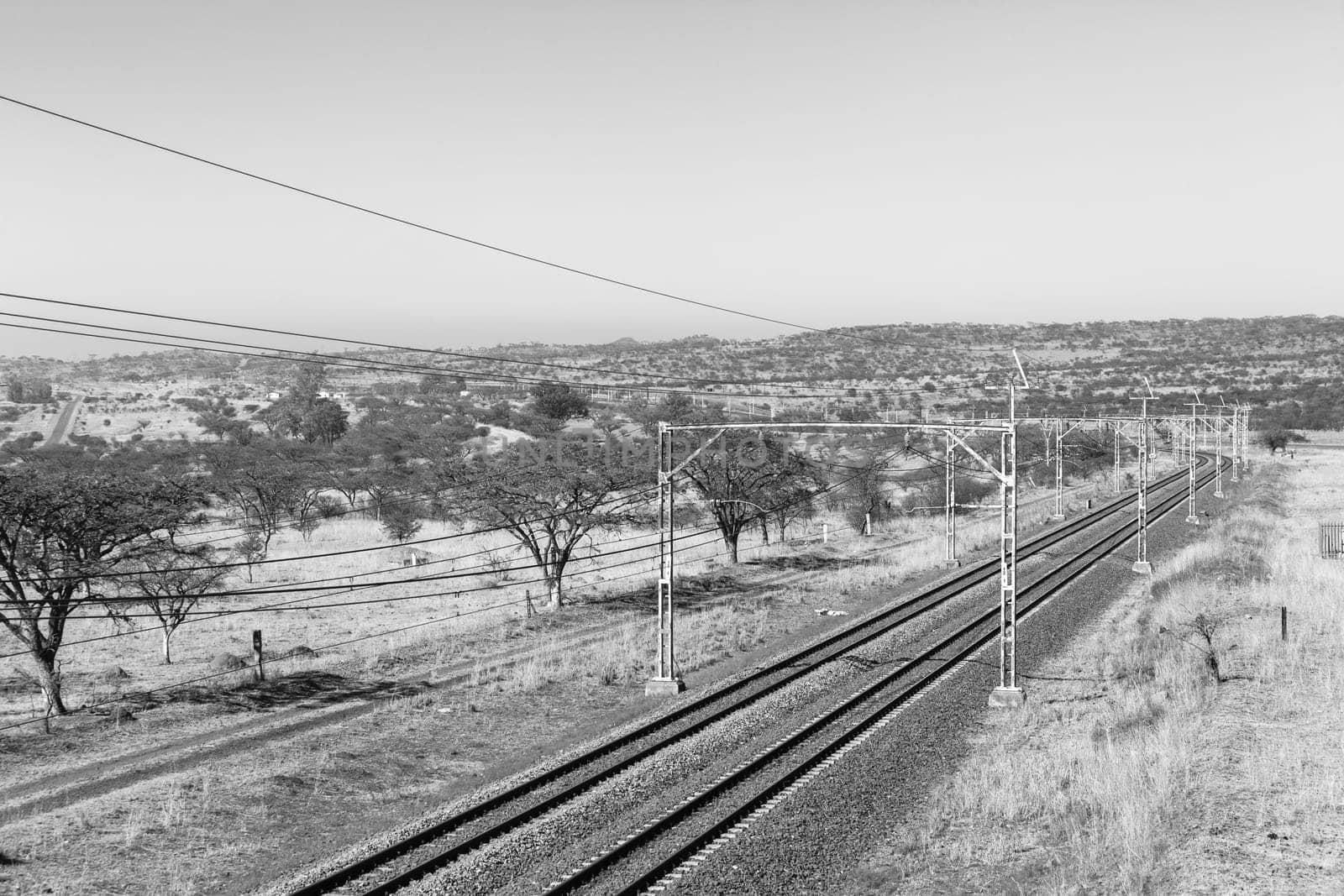 Railway train tracks line travel through dry season rural landscape