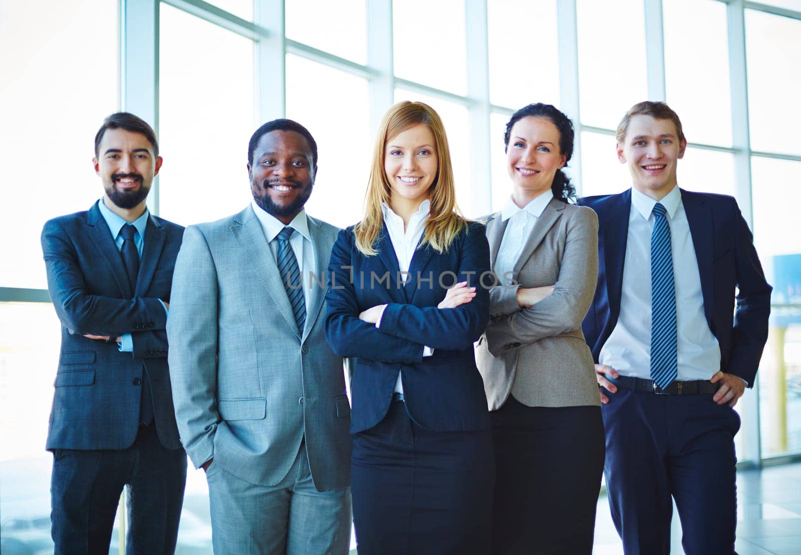 Group of successful business people in formalwear looking at camera