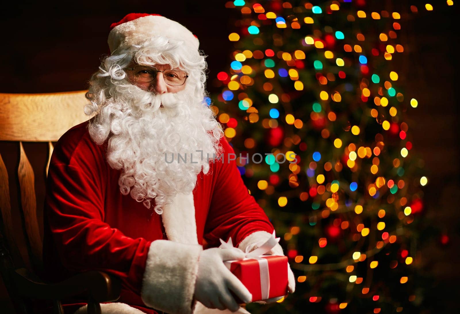 Santa Claus with small giftbox looking at camera