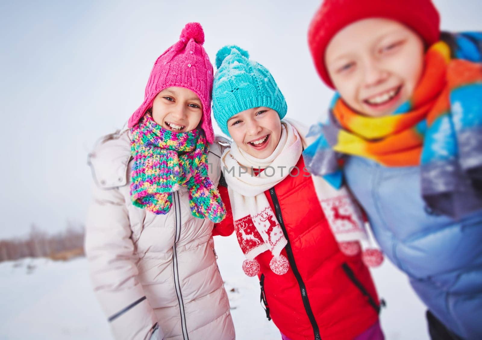 Laughing kids in winterwear having fun outdoors