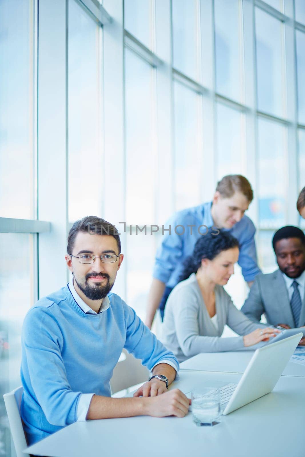 Successful businessman looking at camera in working environment