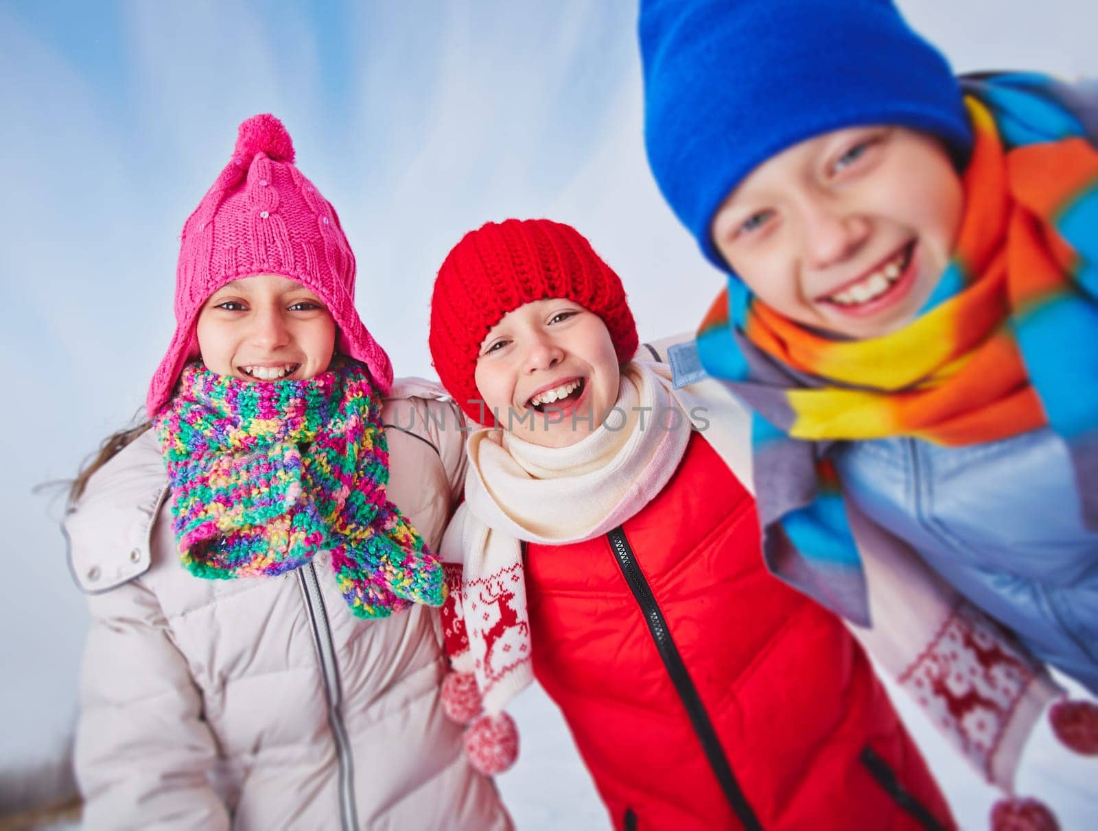 Laughing kids in winterwear looking at camera