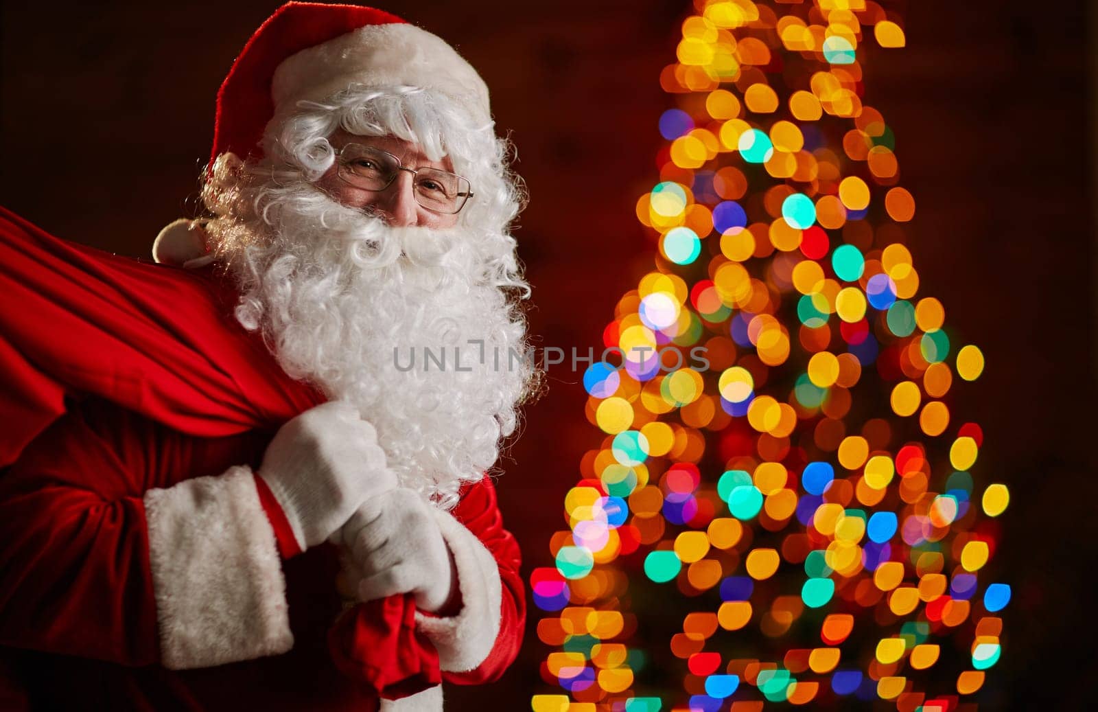 Santa Claus holding carrying sack with gifts for kids