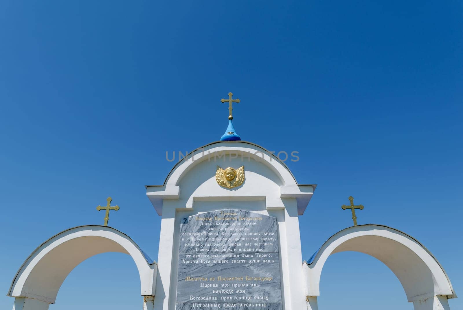 Fragment of a prayer to the Holy Mother of God, engraved on the white tricuspid arch with Orthodox crosses over it