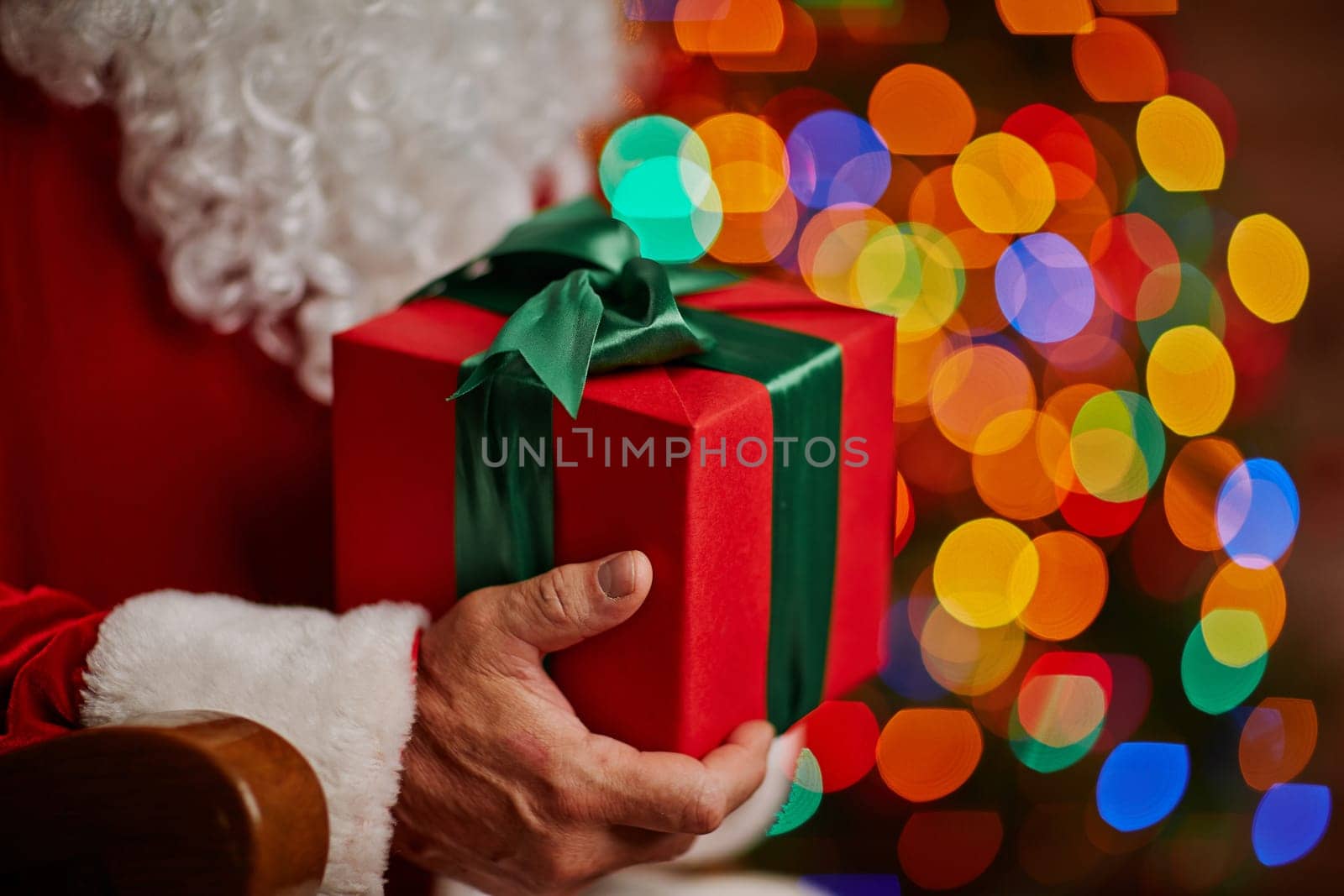 Red box with Christmas gift in Santa hands