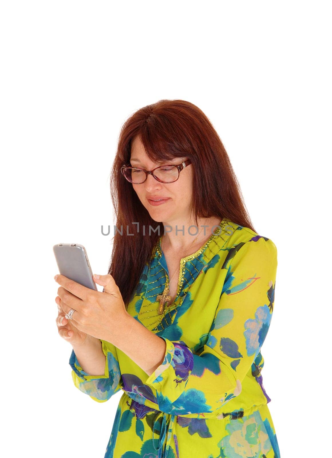 A business woman in a colorful dress holding her glasses and looking at.her cell phone, isolated for white background..